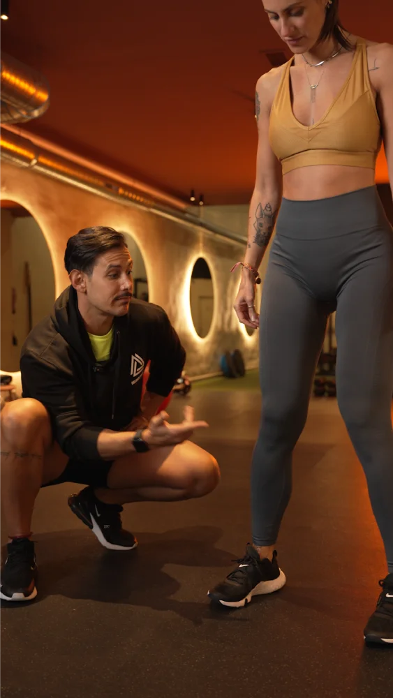 Entrenador y alumna en entrenamiento tren inferior en gimnasio boutique en el Retiro