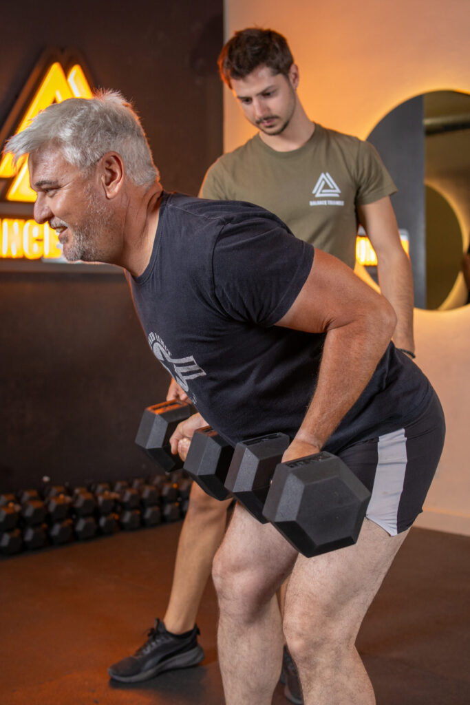 Hombre haciendo ejercicio con entrenador personal